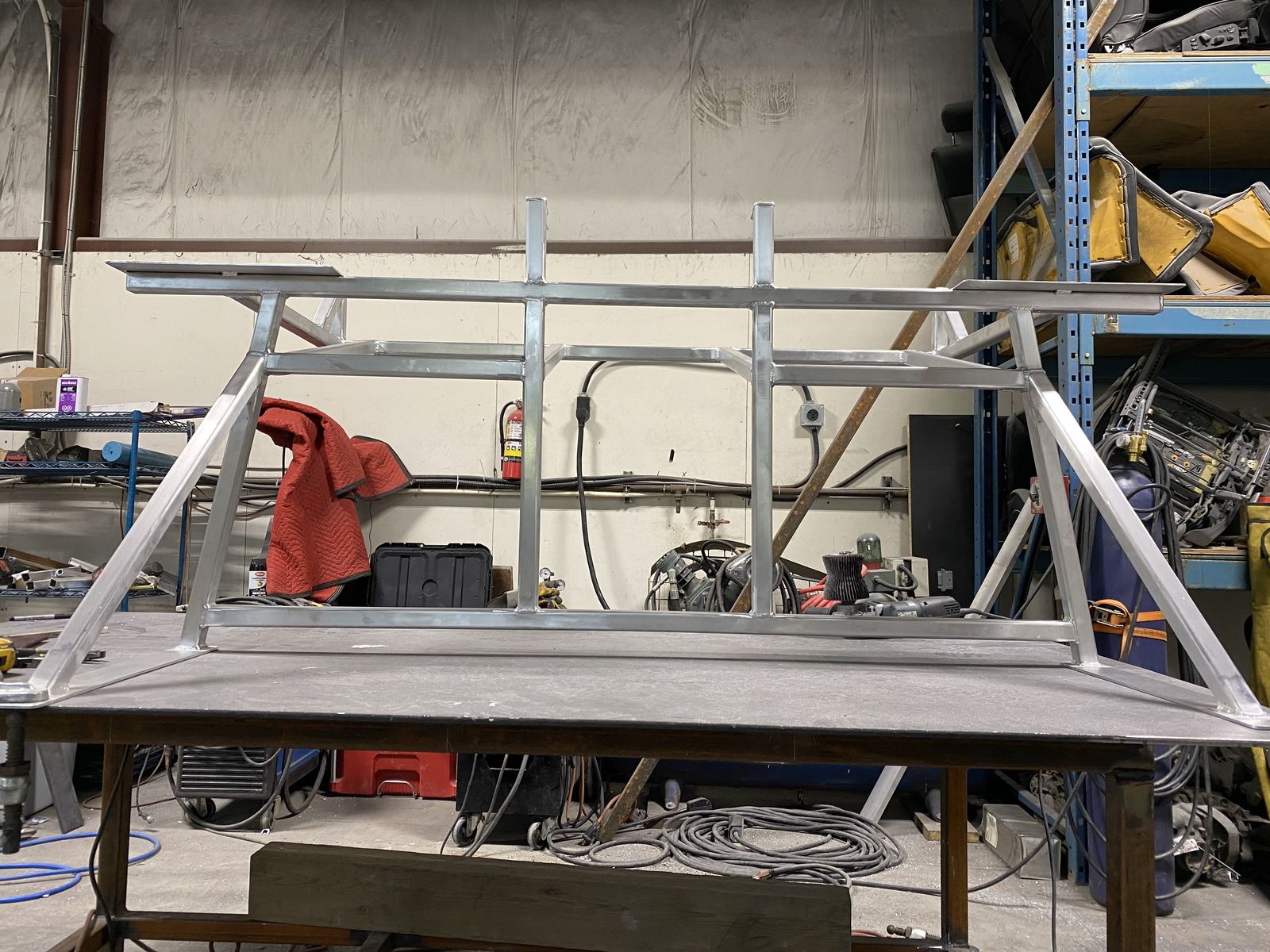 Custom aluminum ladder-style rack on a welding bench