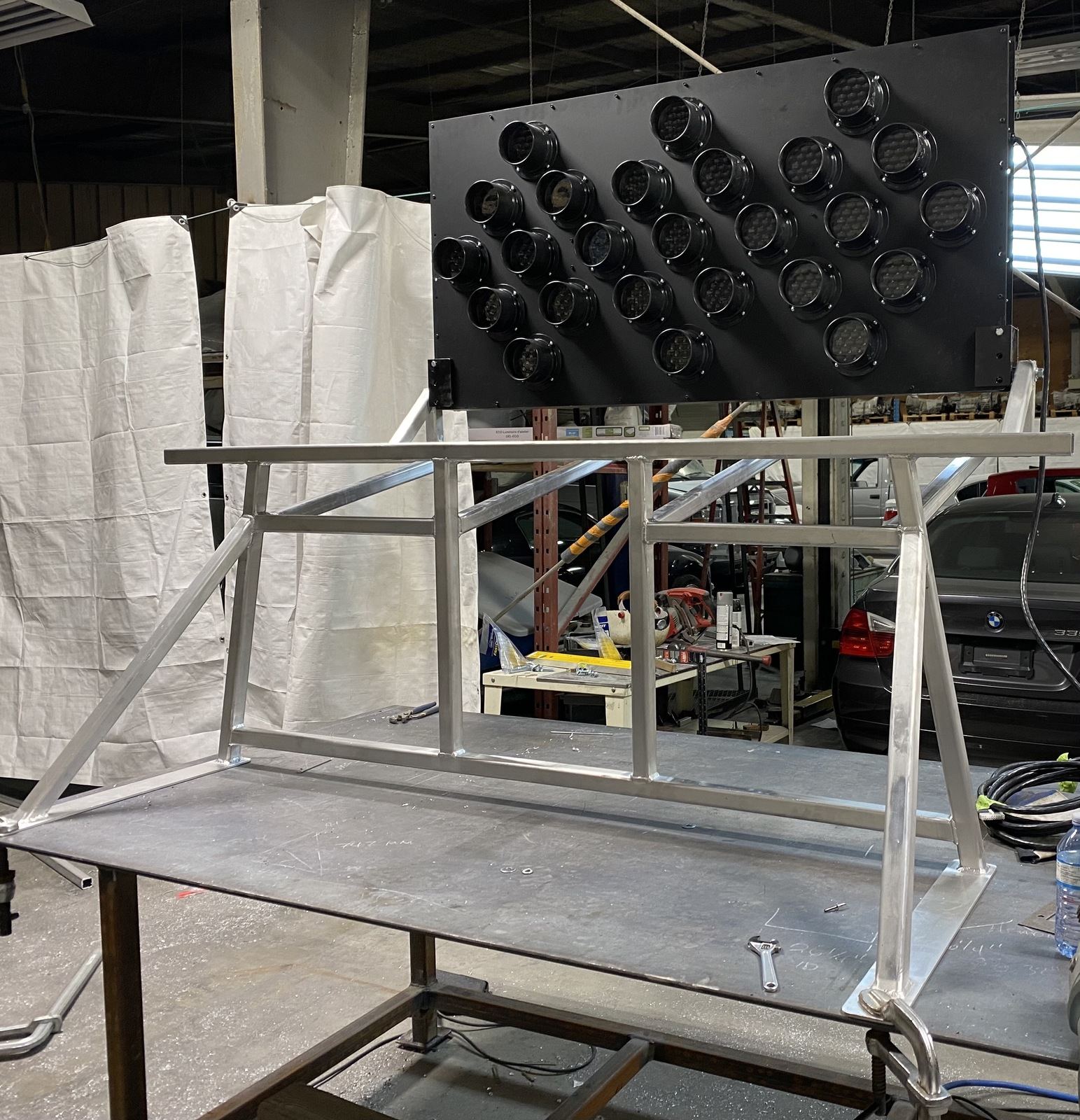 Welded aluminum frame on a shop table with a sign panel mounted above it