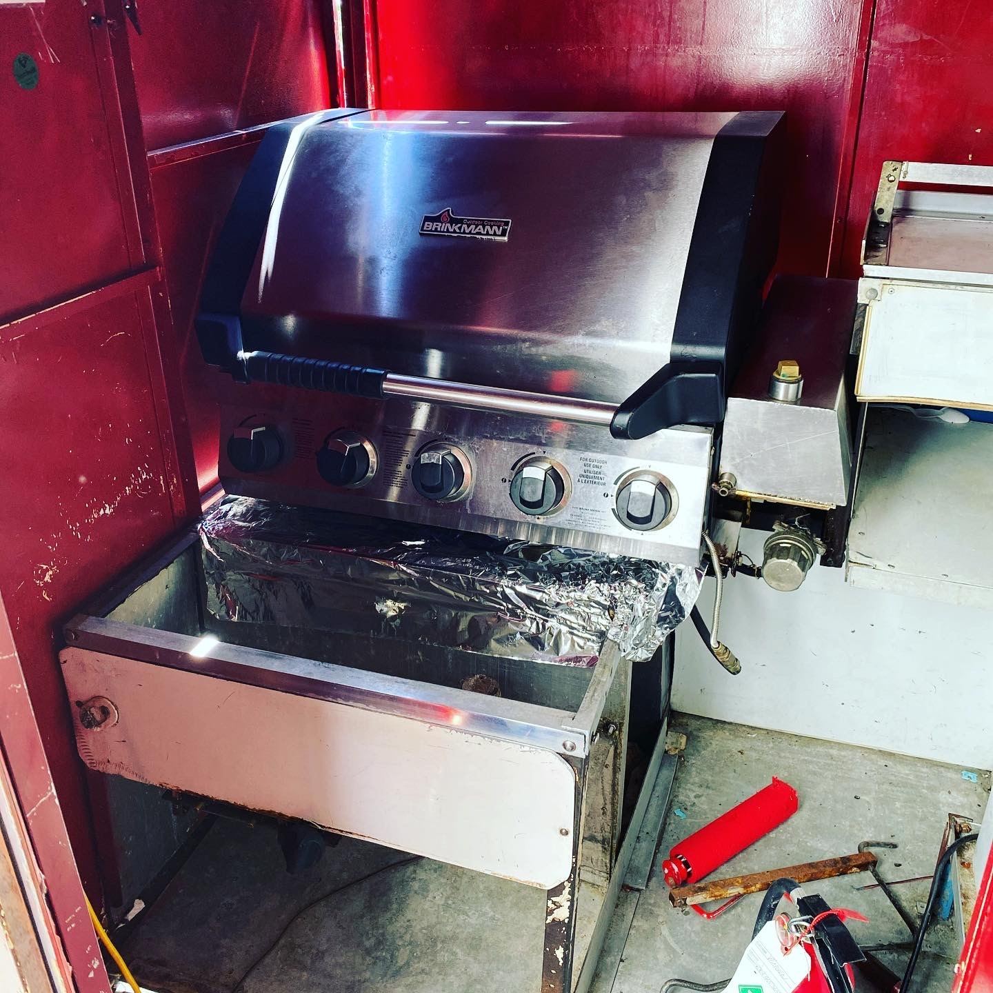 Stainless steel cooking station fitted inside a red food cart