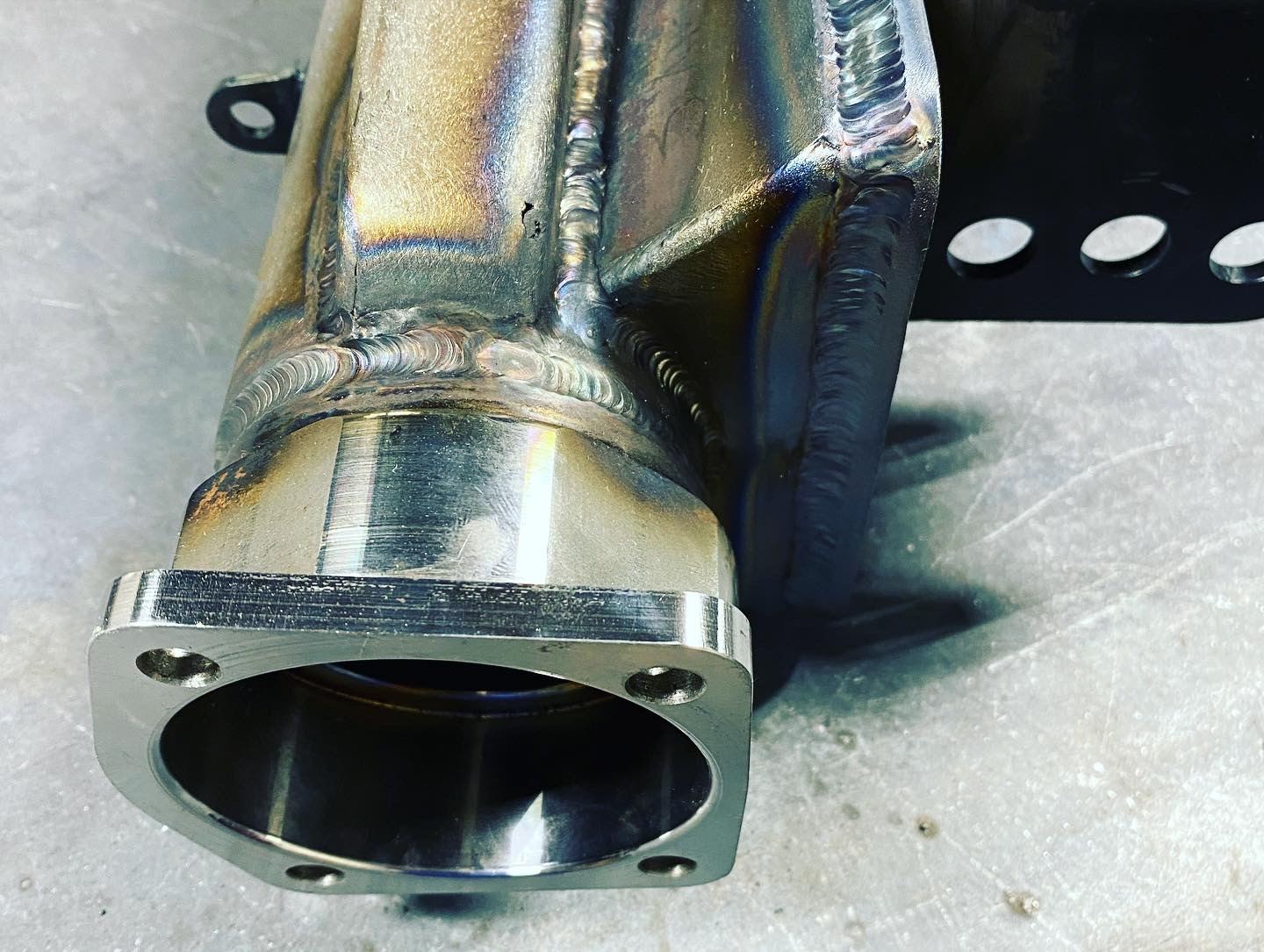 Stainless steel flange TIG-welded onto a fabricated stainless body, heat tint around the weld