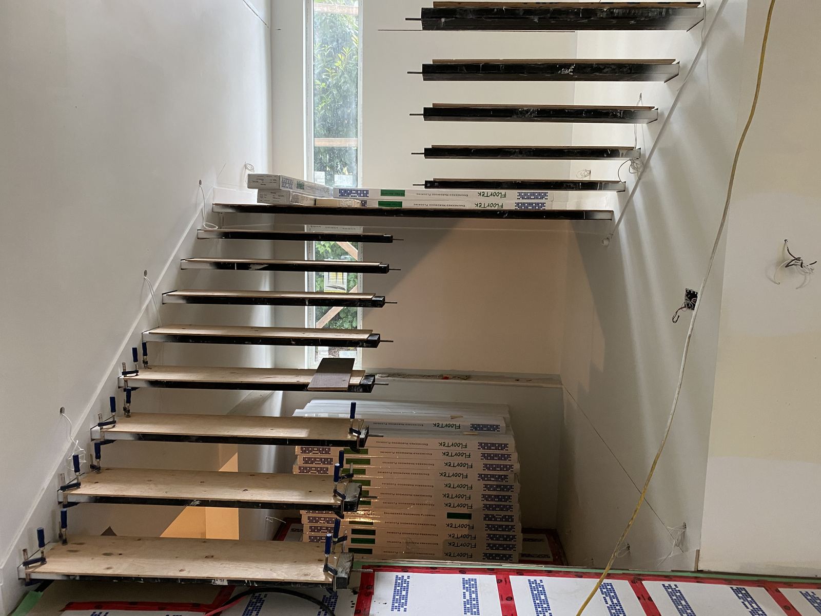 Open-riser floating staircase on custom steel stringer brackets in a new home