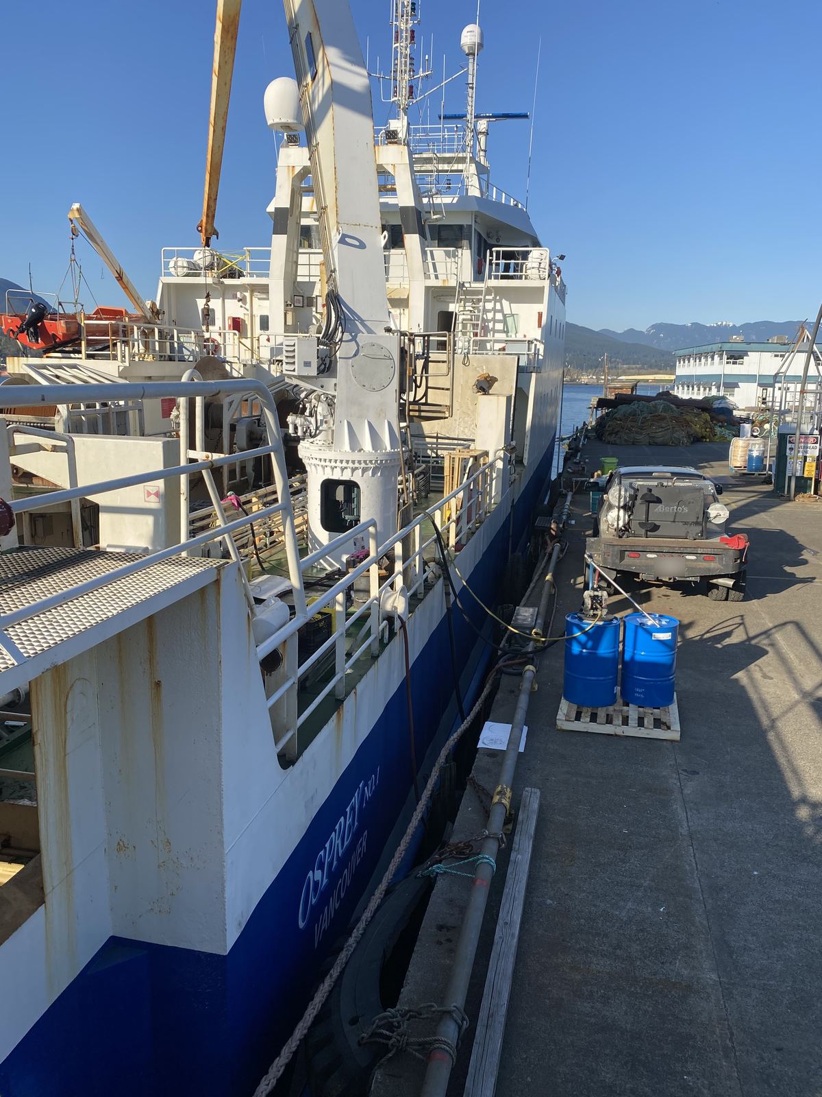 View along the side of the commercial fishing vessel Osprey No. 1, with Berto's welding truck parked on the wharf