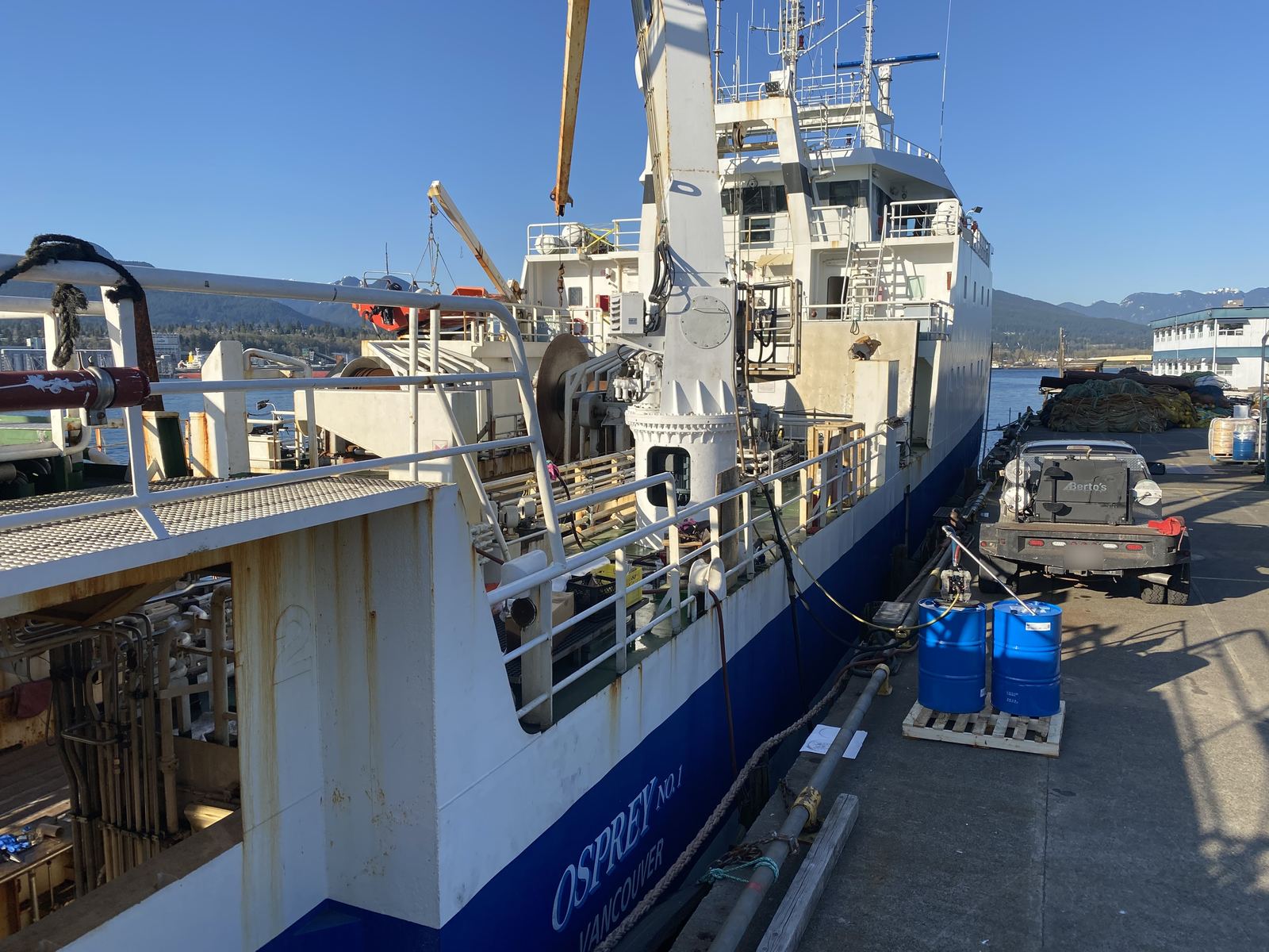 Commercial fishing vessel Osprey No. 1 tied up at a wharf with the Berto's welding truck parked alongside